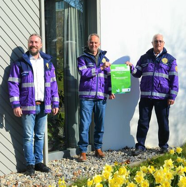 Drei Männer sitzen vor dem "Helios Spital Überlingen".